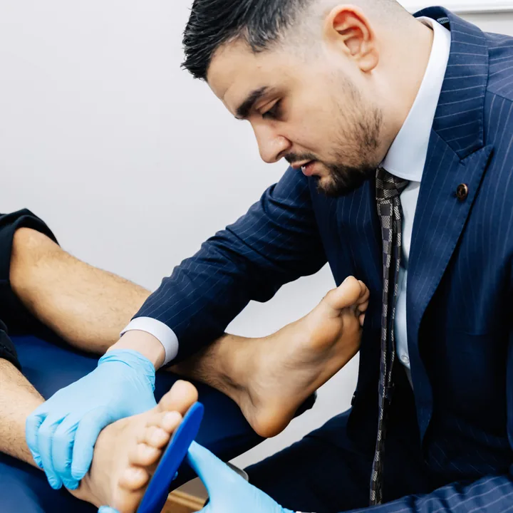 A podiatrist assessing the arch of a patient’s foot