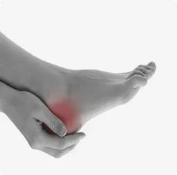 A hand holding a painful heel