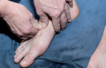 A practitioner mobilising the joints of a foot