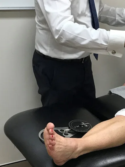 A Dr. Abbie Clinics podiatrist examining a patient’s lower leg