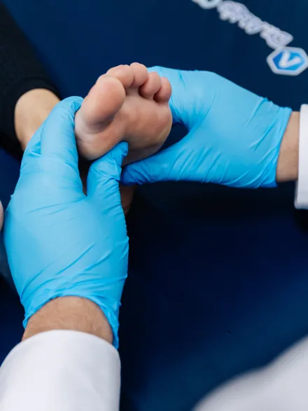 A podiatrist mobilising a patient’s foot by hand