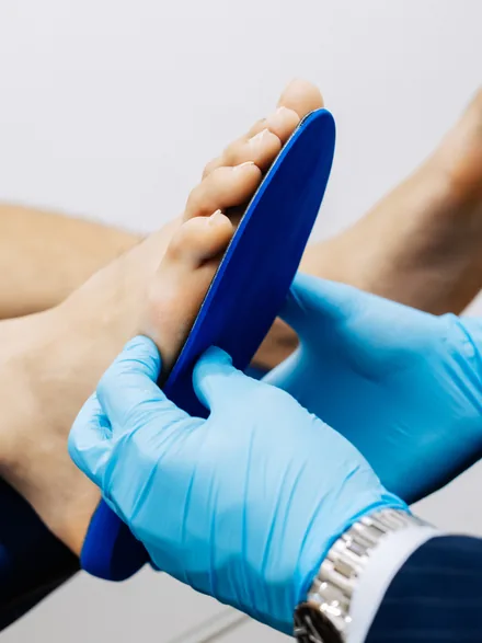 A custom orthotic device being fitted against a patient’s foot