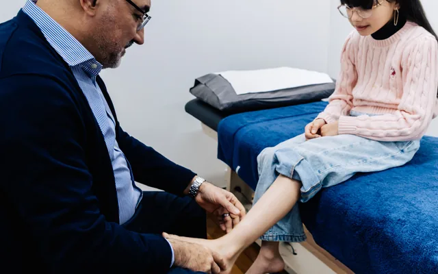 Dr Abbie Najjarine assessing a child’s foot in clinic