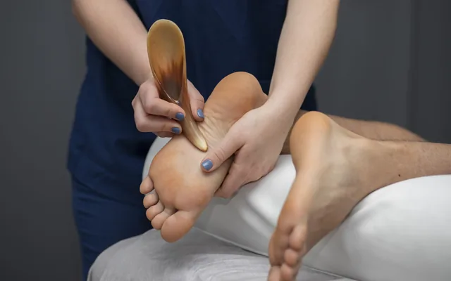 A foot being treated with a podiatry tool