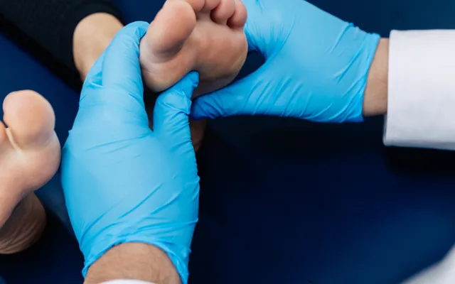 A podiatrist mobilising a patient’s foot by hand