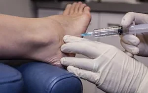 An injection being administered to a patient’s foot