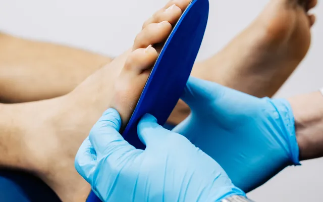 A custom orthotic device being fitted against a patient’s foot